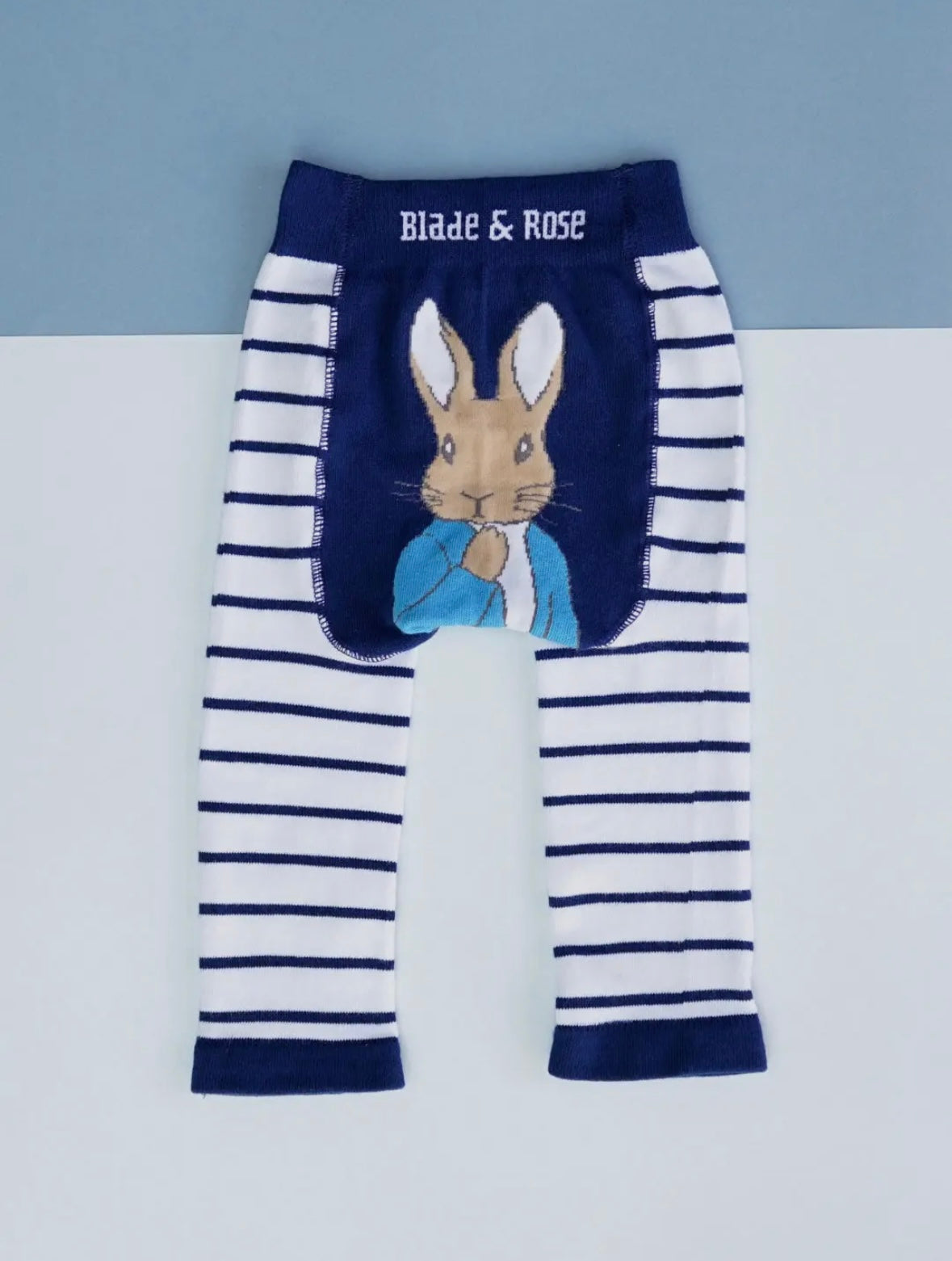 Striped leggings with a Peter Rabbit design on a light gray background