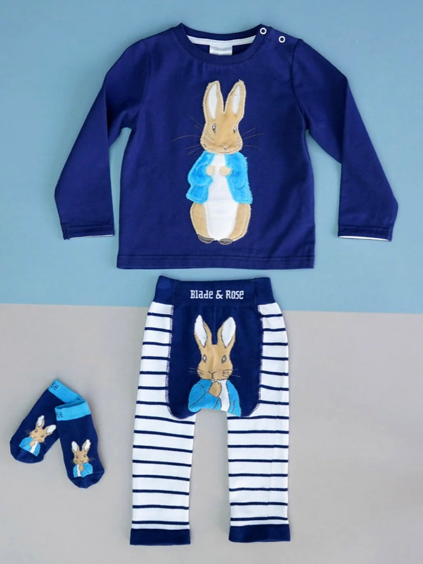 Children's Peter Rabbit outfit set with navy long-sleeve shirt, striped pants, and socks featuring a rabbit design on a blue and gray background.